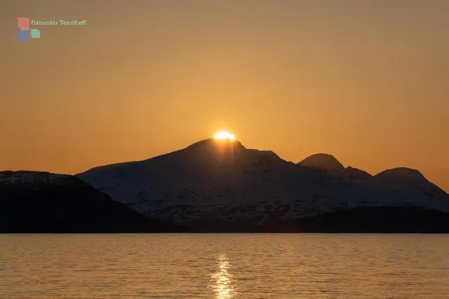 The midnight sun over the island of Reinøya in the Ullsfjord in Norway