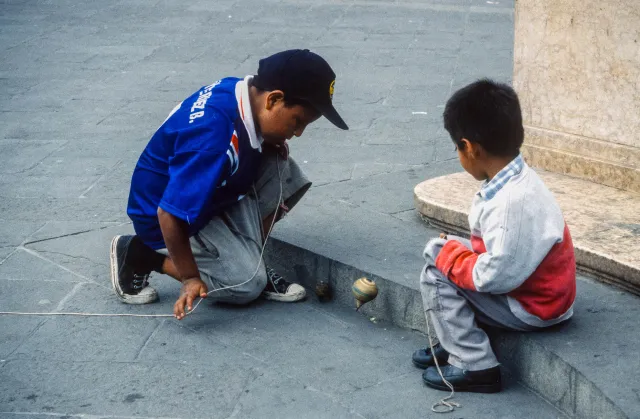 Kinder spielen mit Kreiseln