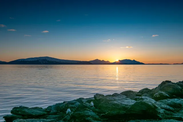 The midnight sun over the island of Reinøya in the Ullsfjord in Norway